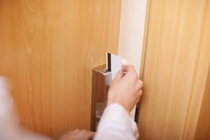 Closeup of female hand holding cardkey and opening door of hotel room